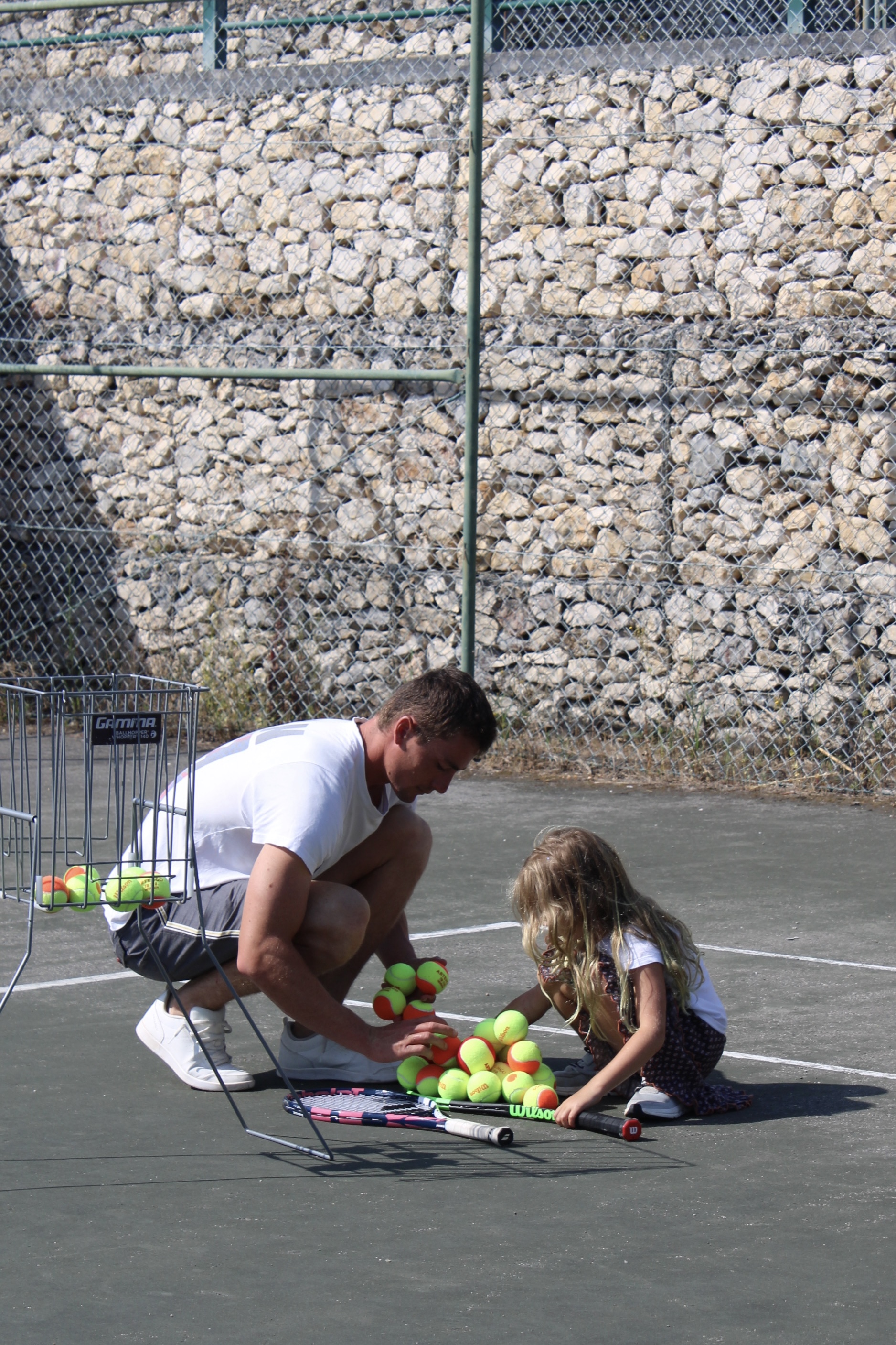 Matisse coaching a young girl on the tennis court